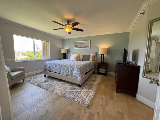 a living room with a bed furniture flat screen tv and a large window