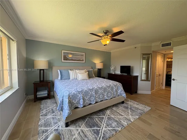 a bedroom with a large bed and a chandelier