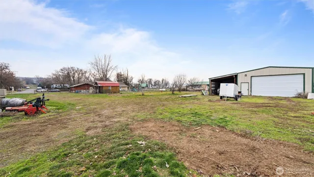 a view of a house with a big yard and large trees