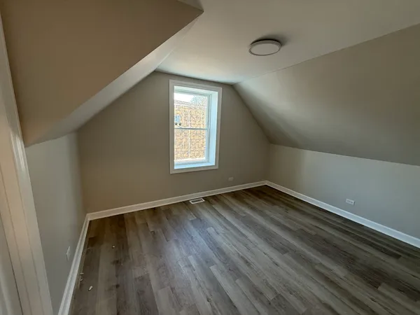 a view of a hallway with wooden floor and windows