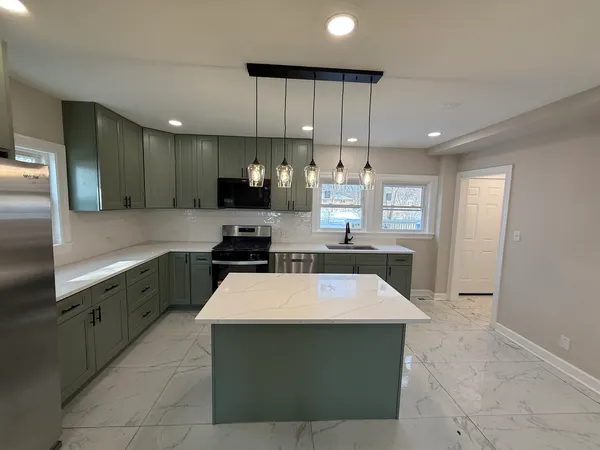 a kitchen with stainless steel appliances granite countertop a sink counter space cabinets and a large window