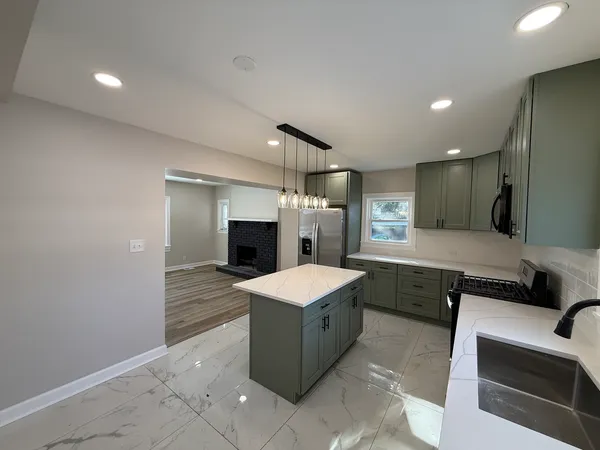 a large kitchen with stainless steel appliances granite countertop a lot of cabinets and wooden floor