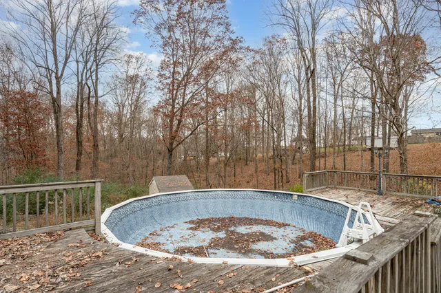 a view of a swimming pool with a barbeque and wooden fence