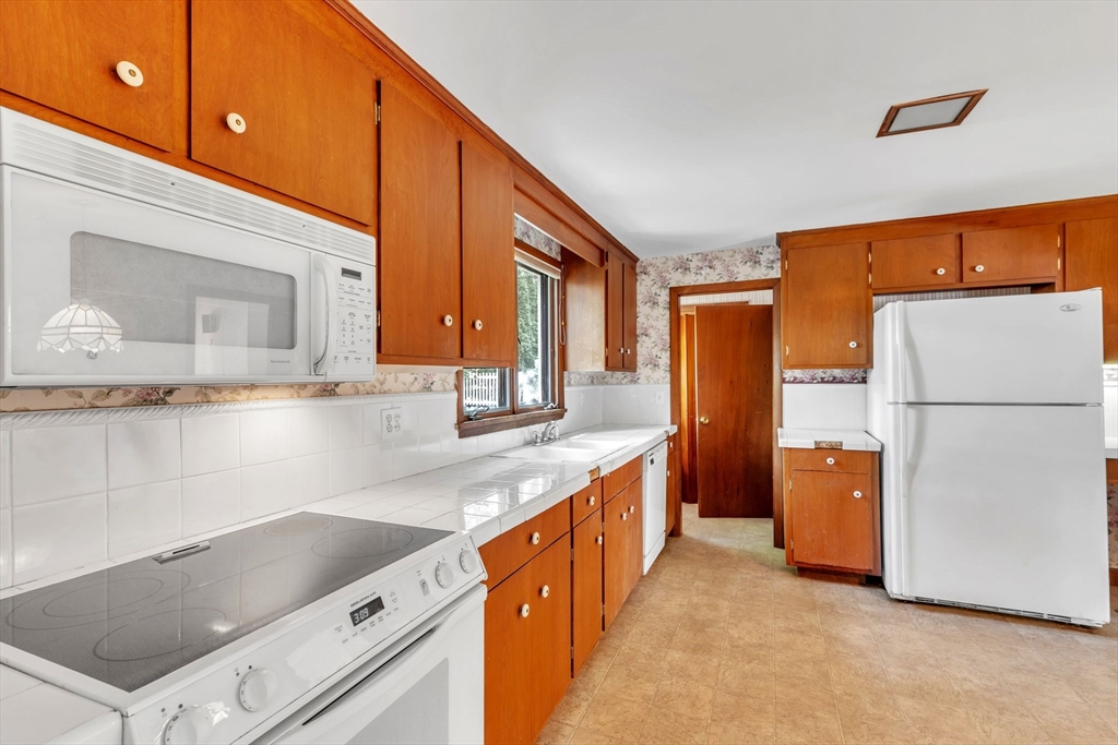 4 Birch Road Swampscott, MA 01907 - Photo 13 of 42 a kitchen with stainless steel appliances granite countertop a refrigerator a stove and a sink with large cabinets