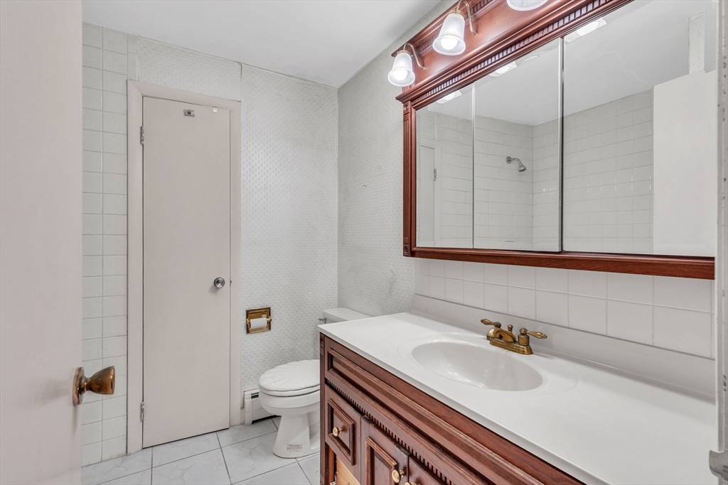 4 Birch Road Swampscott, MA 01907 - Photo 22 of 42 a bathroom with a granite countertop sink toilet a mirror and shower
