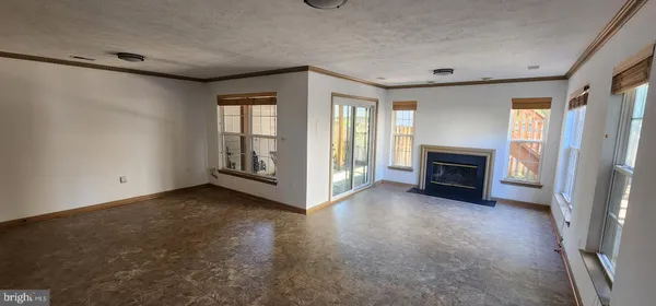 a view of an empty room with a fireplace and a window