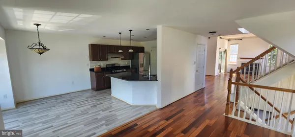 a view of a kitchen with wooden floor and staircase