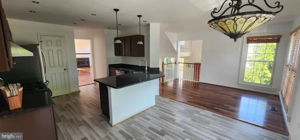 a kitchen view with wooden floor and window
