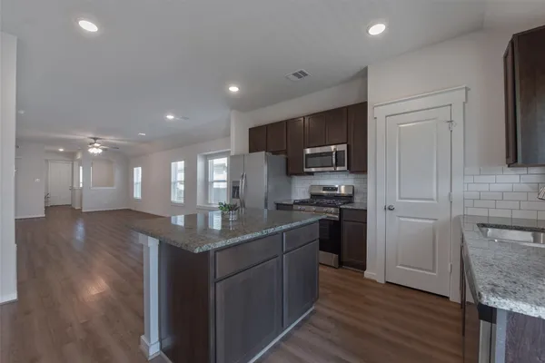 a kitchen with stainless steel appliances granite countertop a sink stove and refrigerator
