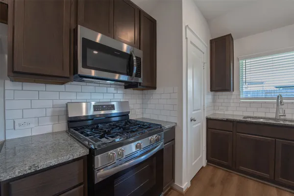 a kitchen with stainless steel appliances granite countertop a stove and a microwave