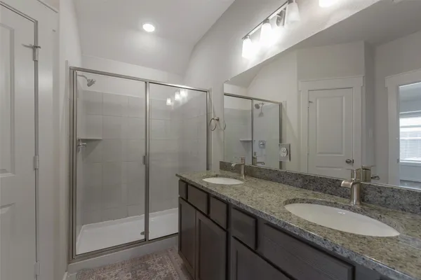 a bathroom with a granite countertop sink mirror and shower