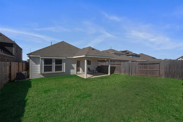 a view of a yard in front of a house with large trees