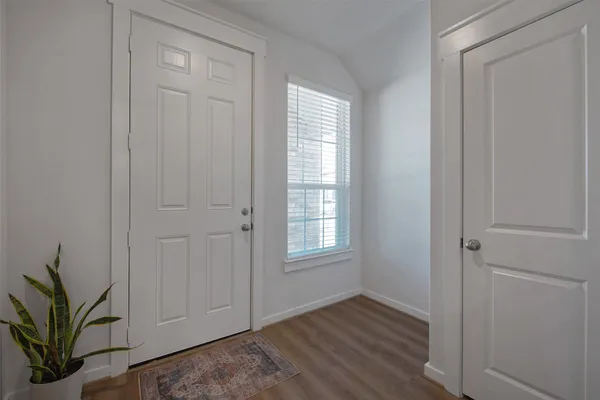 an empty room with wooden floor and window