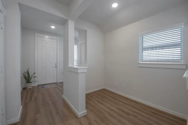 a view of a room with wooden floor and a window