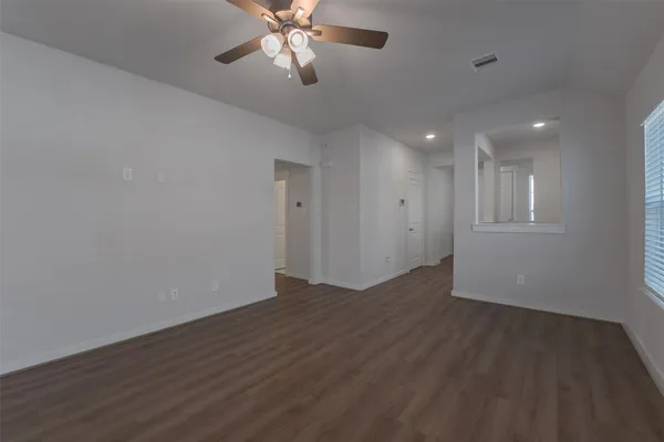 a view of an empty room with a chandelier fan