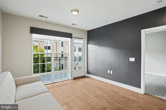 a kitchen with a sink a refrigerator and wooden floor