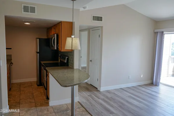 a kitchen with stainless steel appliances granite countertop a sink and a refrigerator