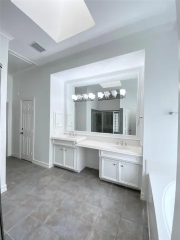 a bathroom with a double vanity sink a mirror and a bathtub