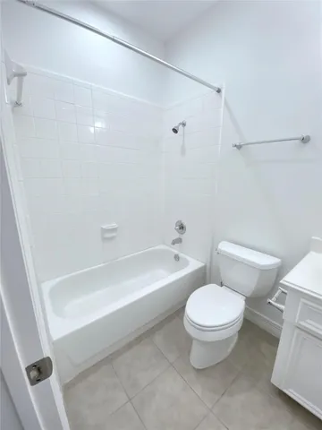 a white toilet sitting next to a bath tub and a shower