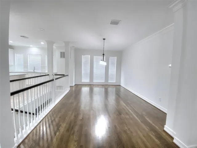a view of an empty room with wooden floor