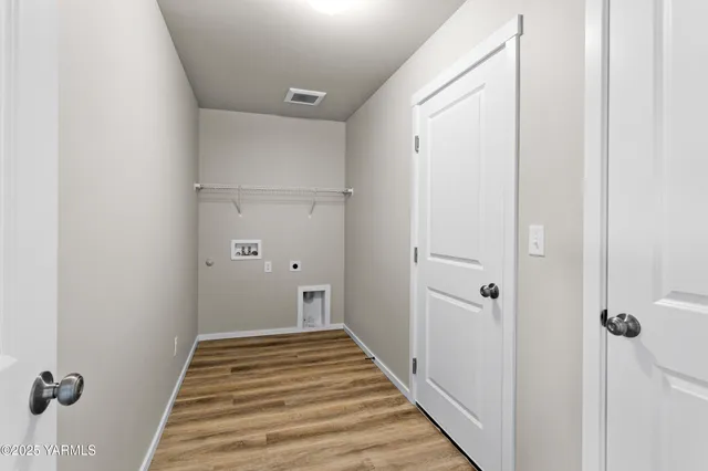a view of a hallway with wooden floor and entryway