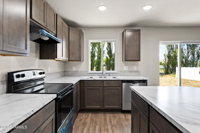 a kitchen with a sink stove top oven and refrigerator