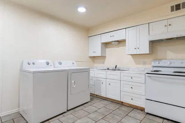 a utility room with cabinets washer and dryer