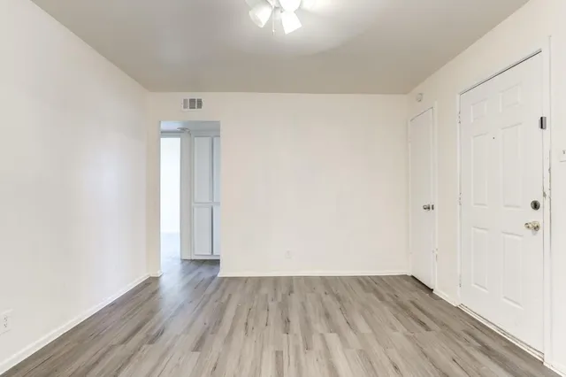 a view of an empty room with wooden floor