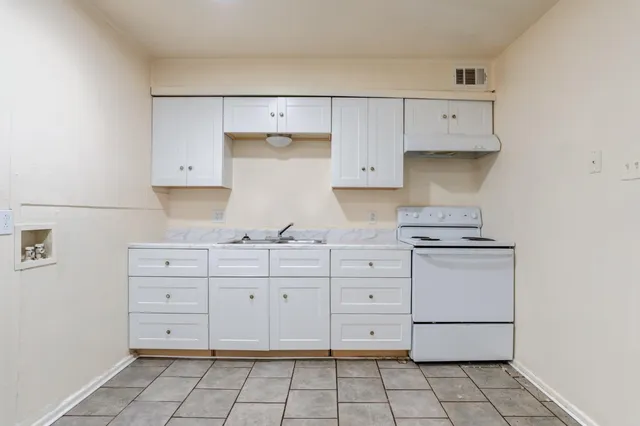 a kitchen with granite countertop white cabinets and white appliances