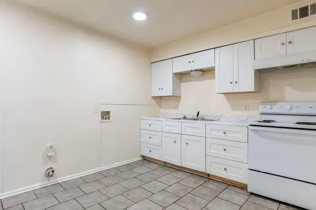 a kitchen with granite countertop white cabinets and white appliances