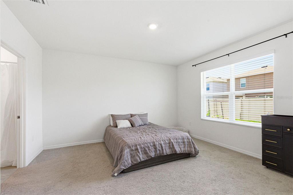 2959 Common Fig Run Wesley Chapel, FL 33543 - Photo 21 of 36 a bedroom with a bed and a window