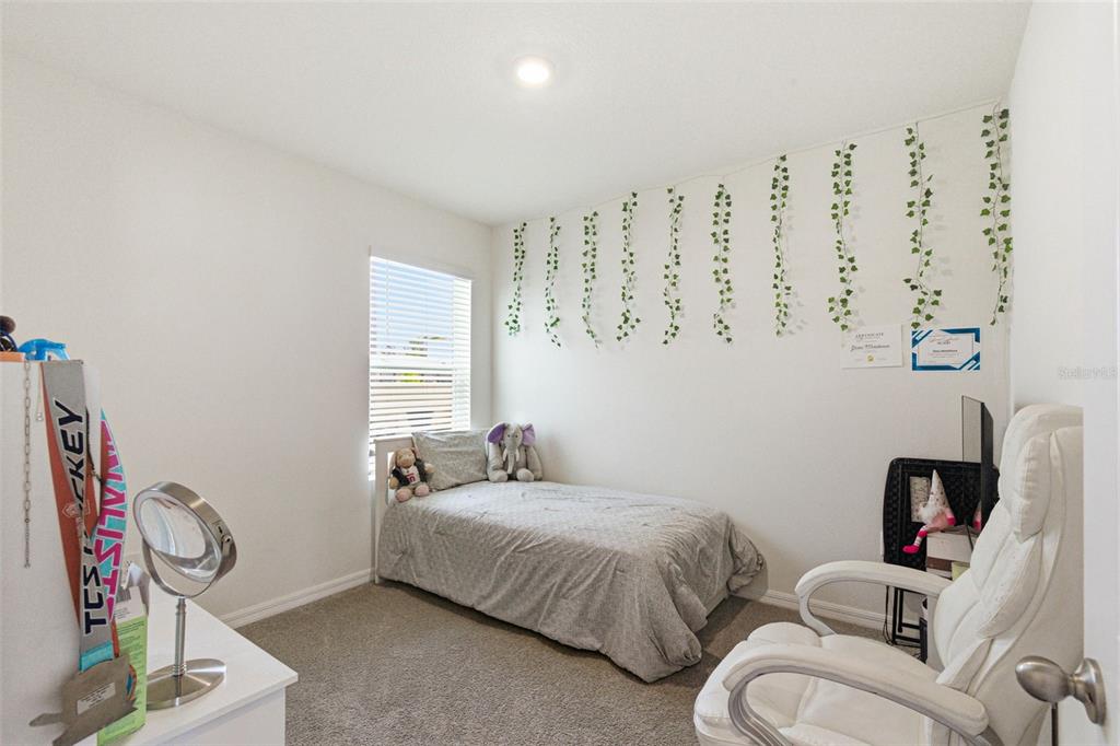 2959 Common Fig Run Wesley Chapel, FL 33543 - Photo 25 of 36 a bedroom with bed and a couch