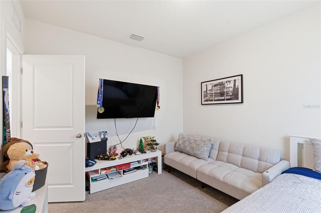 2959 Common Fig Run Wesley Chapel, FL 33543 - Photo 27 of 36 a living room with furniture and a flat screen tv