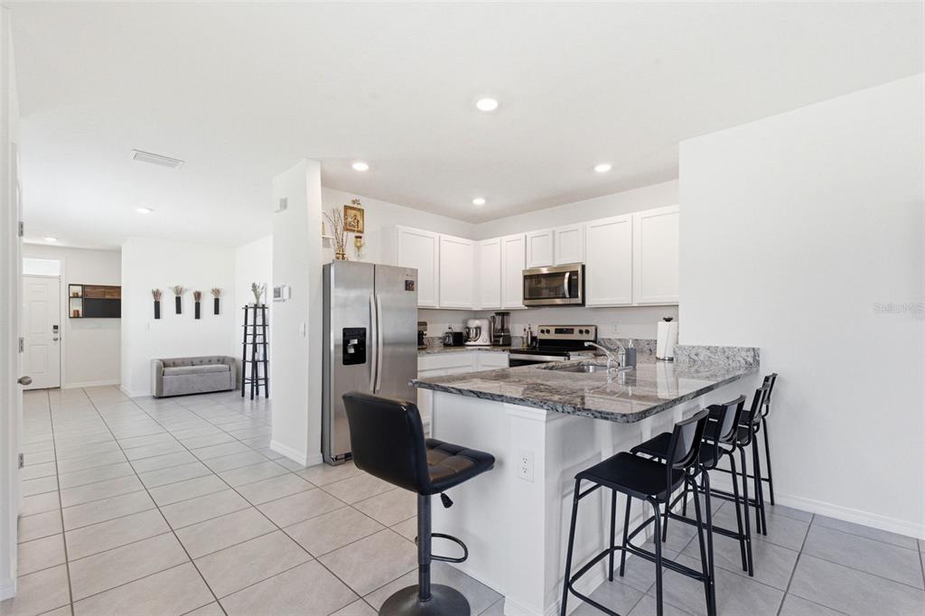 2959 Common Fig Run Wesley Chapel, FL 33543 - Photo 8 of 36 a kitchen with stainless steel appliances a refrigerator and a stove top oven