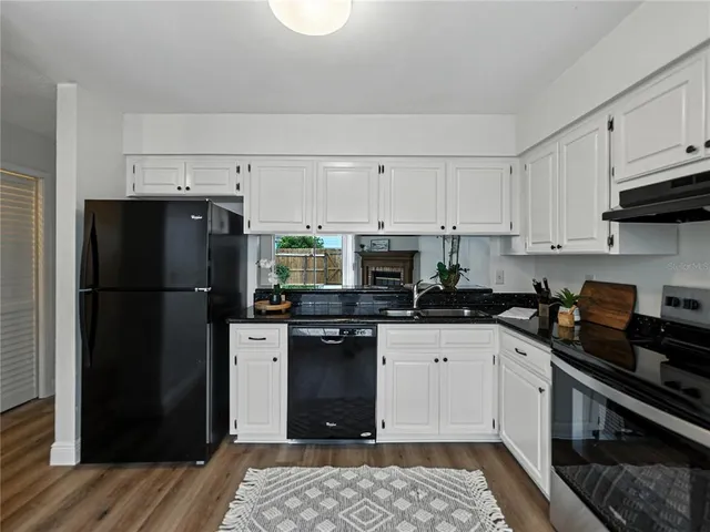 a kitchen with granite countertop a stove sink and cabinets