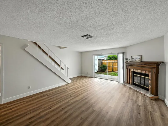 a view of empty room with wooden floor and fireplace