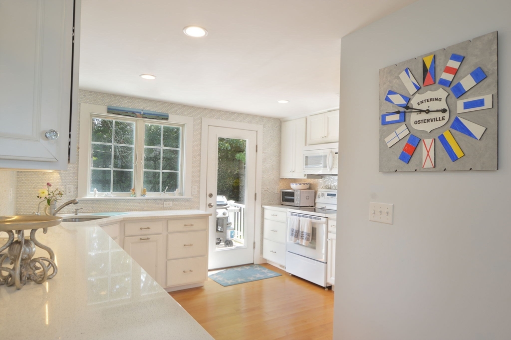47 Great Bay Road Osterville, MA 02655 - Photo 14 of 38 a kitchen with stainless steel appliances a stove a sink and a refrigerator with white cabinets