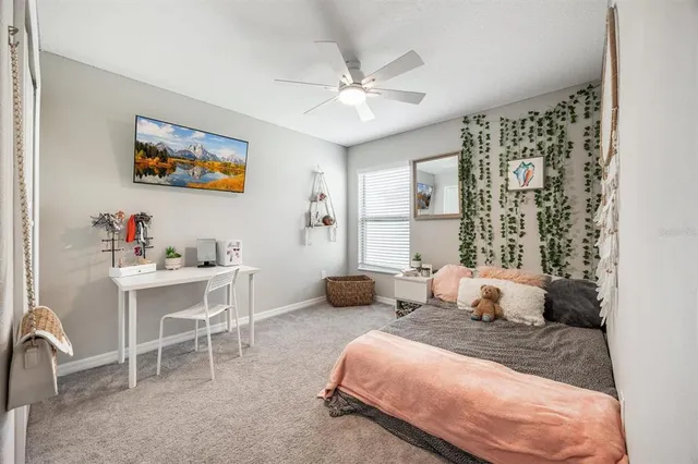a bedroom with a bed a large window and a chandelier