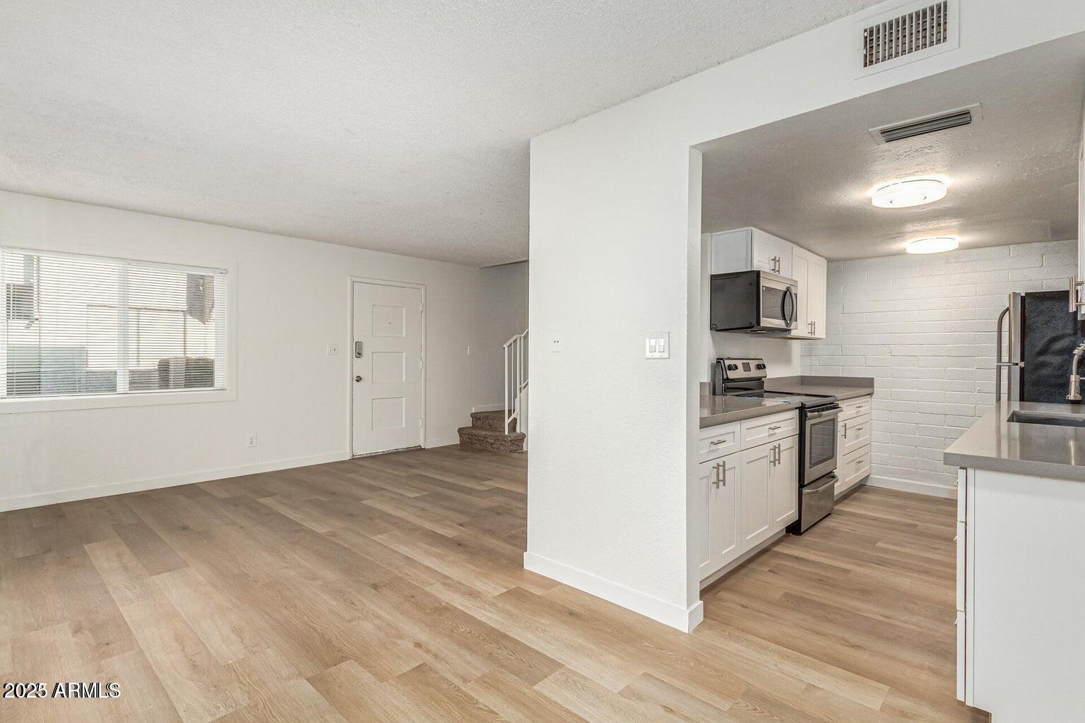 600 South Dobson Road, Unit 69 Mesa, AZ 85202 - Photo 16 of 24 a kitchen with cabinets and wooden floor