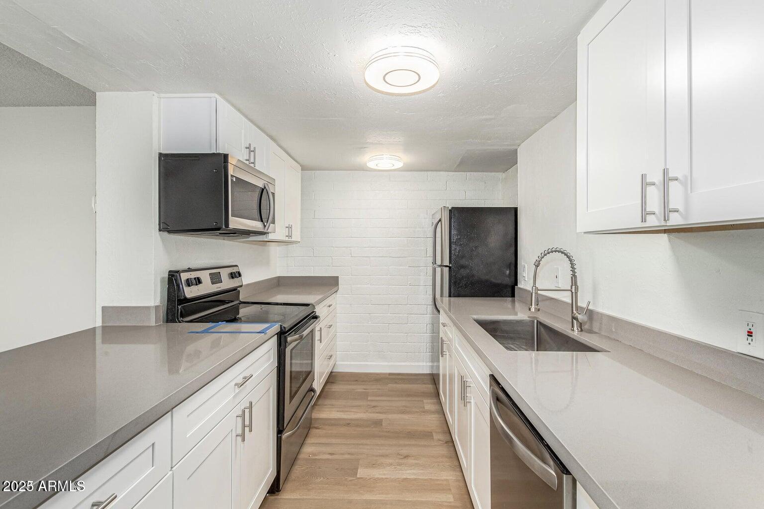 600 South Dobson Road, Unit 69 Mesa, AZ 85202 - Photo 17 of 24 a kitchen with stainless steel appliances granite countertop a sink stove and refrigerator