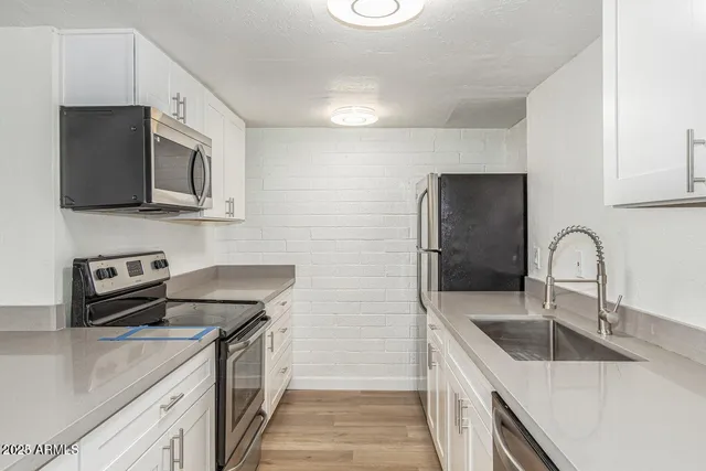 a kitchen with stainless steel appliances granite countertop a sink stove and refrigerator