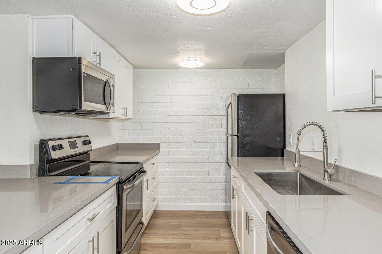 600 South Dobson Road, Unit 69 Mesa, AZ 85202 - Photo 18 of 24 a kitchen with stainless steel appliances granite countertop a sink stove and refrigerator