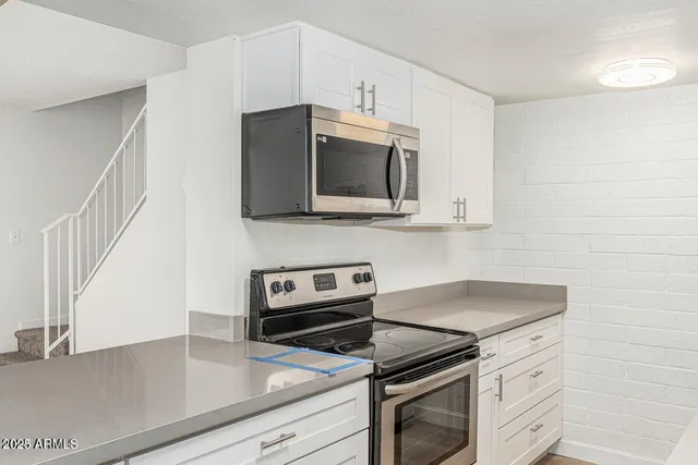 a kitchen with stainless steel appliances a stove microwave and sink