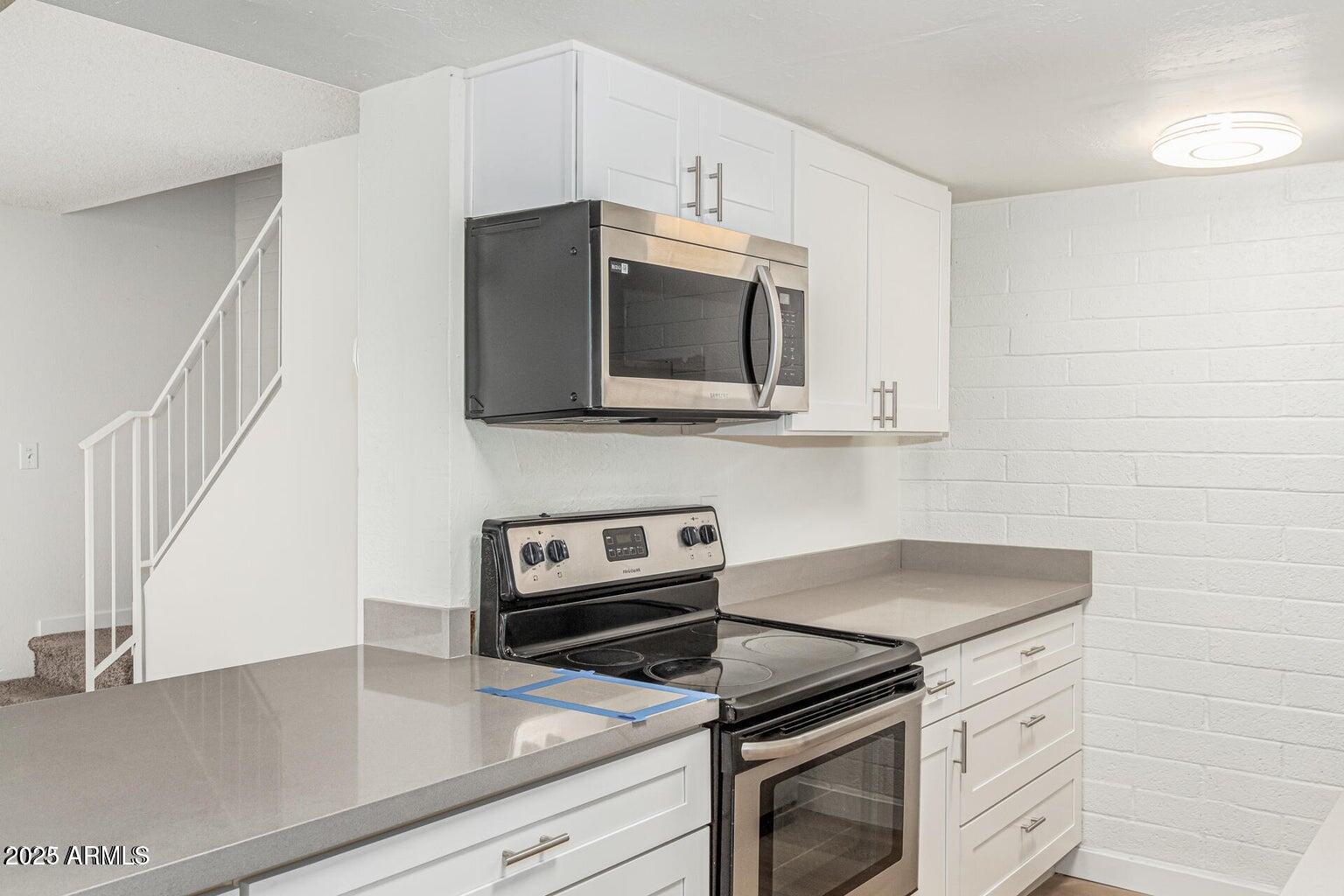 600 South Dobson Road, Unit 69 Mesa, AZ 85202 - Photo 21 of 24 a kitchen with stainless steel appliances a stove microwave and sink