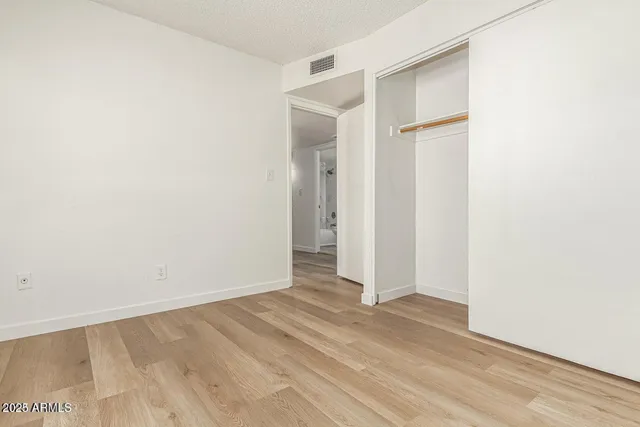 a view of an empty room with closet and a window