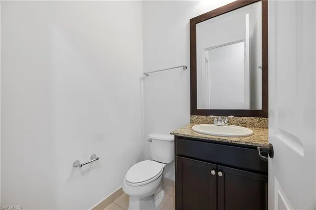 a bathroom with a granite countertop sink toilet and mirror