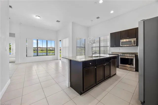 a large kitchen with stainless steel appliances a stove a sink and a refrigerator
