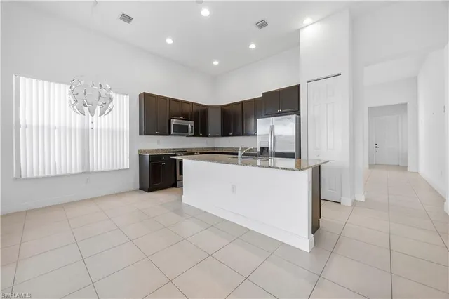 a view of kitchen with stainless steel appliances granite countertop a stove a sink and a microwave