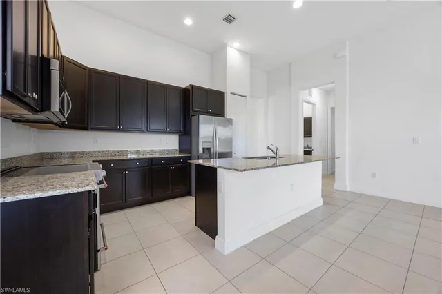a kitchen with a sink counter top space appliances and cabinets