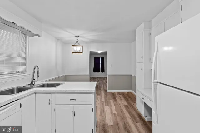 a kitchen with a sink refrigerator and cabinets